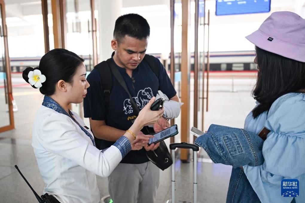 10月12日，在老撾萬象中老鐵路萬象站，工作人員檢驗乘客車票。新華社記者 程一恒 攝