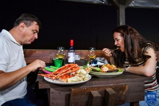 9月2日，食客們在俄羅斯符拉迪沃斯托克的一家餐館品嘗帝王蟹。新華社記者 曹陽 攝