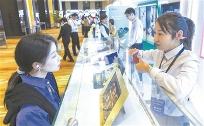 在北京麗澤商務(wù)區(qū)，工作人員（右一）介紹數(shù)字人民幣SIM卡硬錢包。新京報(bào)記者 陶冉攝