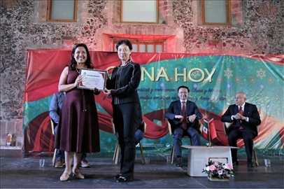 李雅芳向加比拉爾·塞迪略授予“拉美分社榮譽(yù)員工”稱號(hào)。主辦方供圖