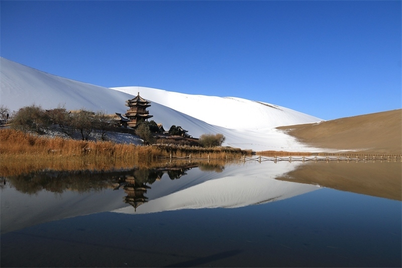 鳴沙山月牙泉景區(qū)雪景。敦煌市委宣傳部供圖，張曉亮攝