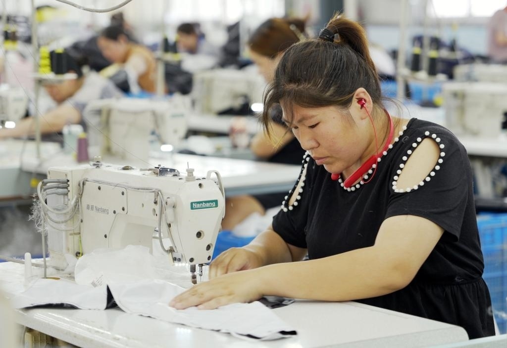 5月20日，村民在李寨村服裝加工廠內(nèi)忙碌。河南省周口市沈丘縣馮營鎮(zhèn)李寨村地處豫東平原。近年來，乘著脫貧攻堅(jiān)與鄉(xiāng)村振興政策的東風(fēng)，李寨村積極探索產(chǎn)業(yè)發(fā)展模式，通過“龍頭企業(yè)+村集體經(jīng)濟(jì)+農(nóng)戶”的方式，逐漸發(fā)展形成肉牛養(yǎng)殖、設(shè)施農(nóng)業(yè)、服裝加工、康養(yǎng)民宿等產(chǎn)業(yè)，以產(chǎn)業(yè)振興助力鄉(xiāng)村振興。新華社記者 李嘉南 攝
