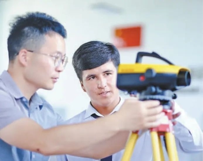 在塔吉克斯坦首都杜尚別的魯班工坊，來(lái)自天津城市建設(shè)管理職業(yè)技術(shù)學(xué)院的老師（左）為當(dāng)?shù)貙W(xué)生提供指導(dǎo)。新華社記者 鄭開(kāi)君 攝