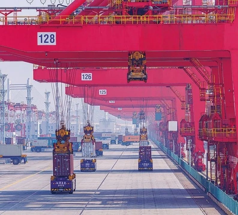 共建“一帶一路”國(guó)家在工作制度對(duì)接、技術(shù)標(biāo)準(zhǔn)協(xié)調(diào)、檢驗(yàn)結(jié)果互認(rèn)等方面強(qiáng)化合作、統(tǒng)一標(biāo)準(zhǔn)，貿(mào)易自由化便利化水平不斷提升。上海洋山港海關(guān)對(duì)接共建國(guó)家進(jìn)出口貨物相關(guān)標(biāo)準(zhǔn)，推動(dòng)通關(guān)一體化方式申報(bào)，提升通關(guān)效率。圖為無(wú)人駕駛的全自動(dòng)導(dǎo)引車(chē)在洋山港穿梭往來(lái)，搬運(yùn)集裝箱。王初 攝