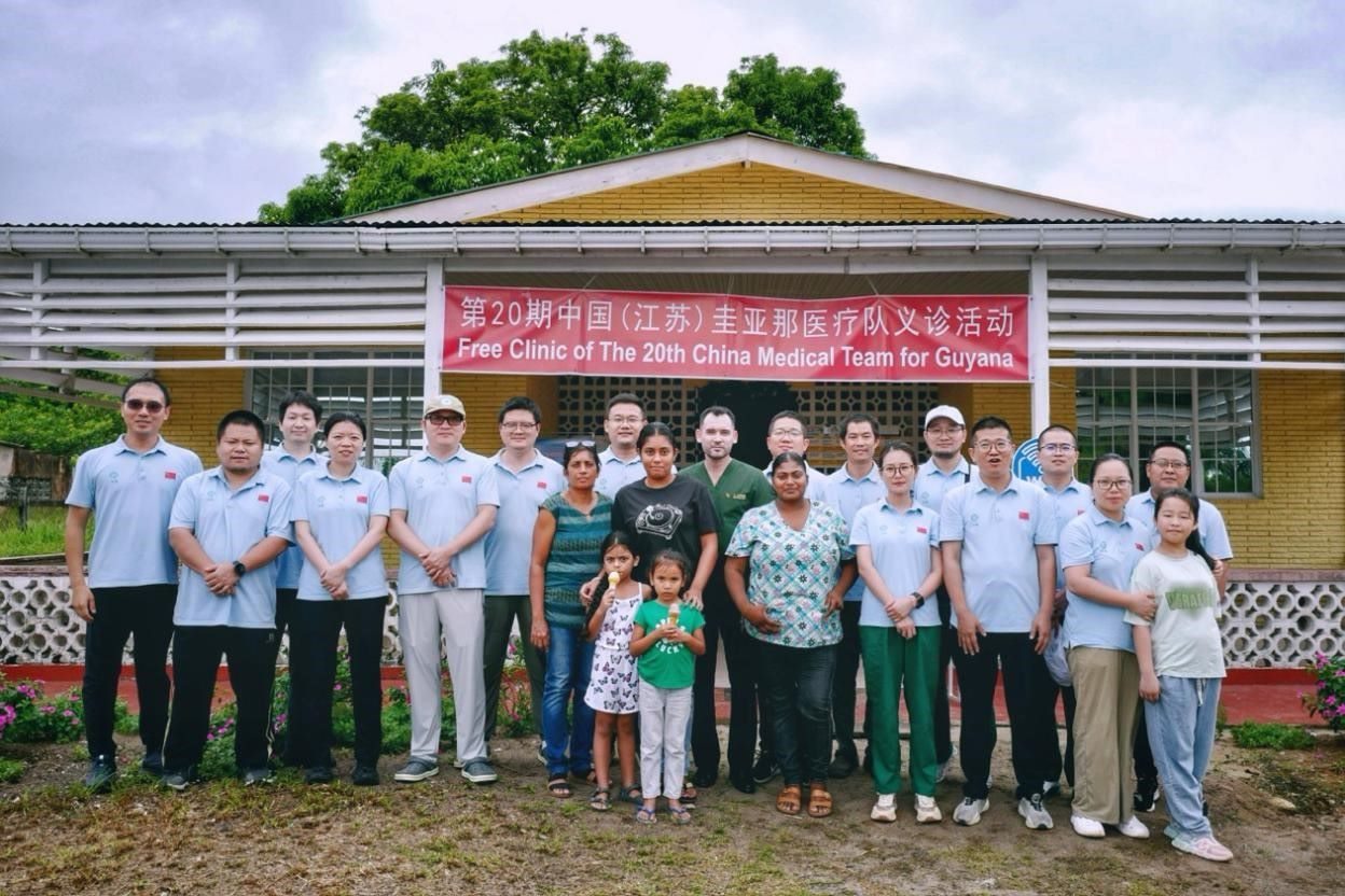 第20期中國(guó)（江蘇）援圭亞那醫(yī)療隊(duì)在圭偏遠(yuǎn)的林登高速社區(qū)開展義診后，與部分當(dāng)?shù)鼐用窈嫌啊?中國(guó)援圭醫(yī)療隊(duì)供圖