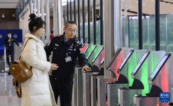 1月2日，大興機(jī)場邊檢站警察指導(dǎo)旅客使用自助出境設(shè)備。新華社記者 李欣 攝