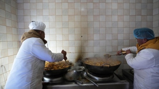 1月14日，服務(wù)隊(duì)的兩名廚師正在為村民們做午飯。新華社記者 邱星翔 攝
