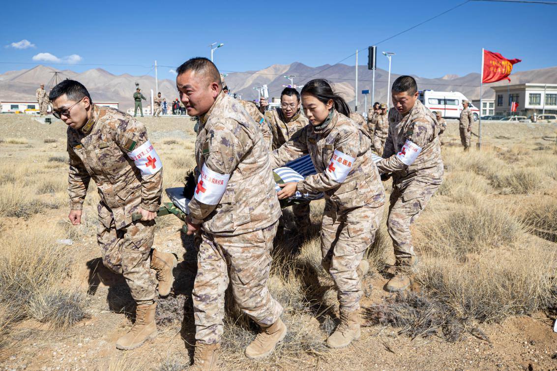 1月9日，日喀則定日縣長所鄉(xiāng)，西藏軍區(qū)總醫(yī)院醫(yī)療隊隊員將受傷村民用擔(dān)架從救護車準(zhǔn)備抬上直升機，轉(zhuǎn)運至拉薩的西藏軍區(qū)總醫(yī)院救治。人民日報記者張武軍攝