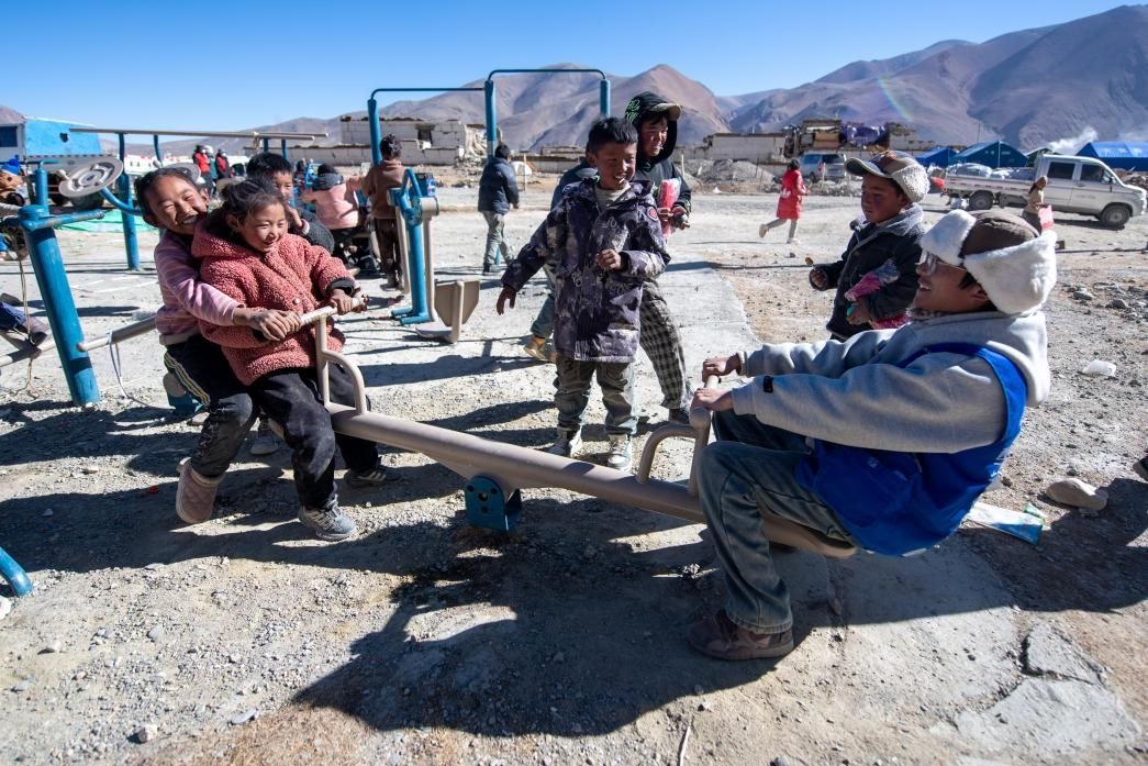 1月11日，在定日縣措果鄉(xiāng)塘仁村安置點，西藏星光社會工作服務(wù)中心志愿者和孩子們一起玩耍，進行災(zāi)后心理疏導(dǎo)。人民網(wǎng)記者 翁奇羽攝