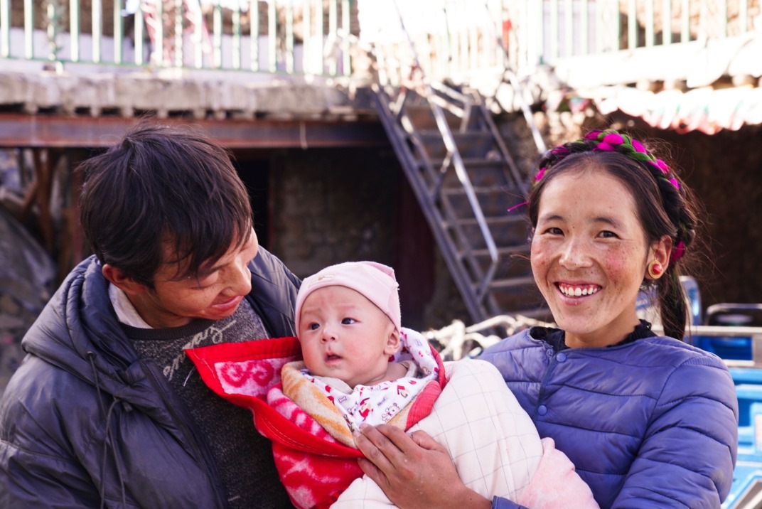1月11日，在西藏日喀則市人民醫(yī)院，受災(zāi)群眾抱著自己在地震中受傷的孩子康復(fù)出院。人民日報記者徐馭堯攝