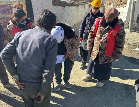 1月13日，次旺（右一）陪同工作組走訪村莊，評估房屋受損程度。新華社發(fā)