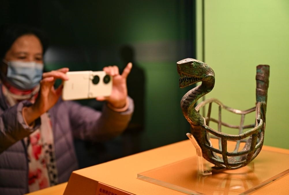 1月14日，觀眾在上海博物館蛇年迎春展拍攝展品蛇綱網(wǎng)狀銅器。新華社發(fā)（陳浩明攝）