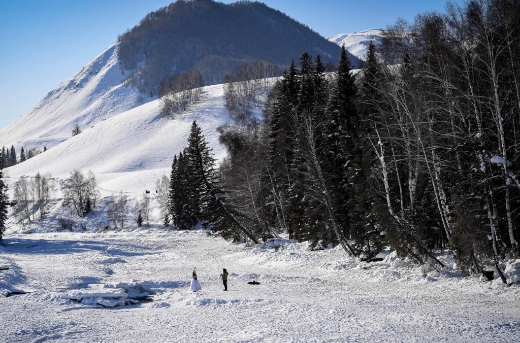 2024年2月5日，兩名游客在新疆阿勒泰地區(qū)布爾津縣禾木村拍照。新華社記者 馬鍇 攝