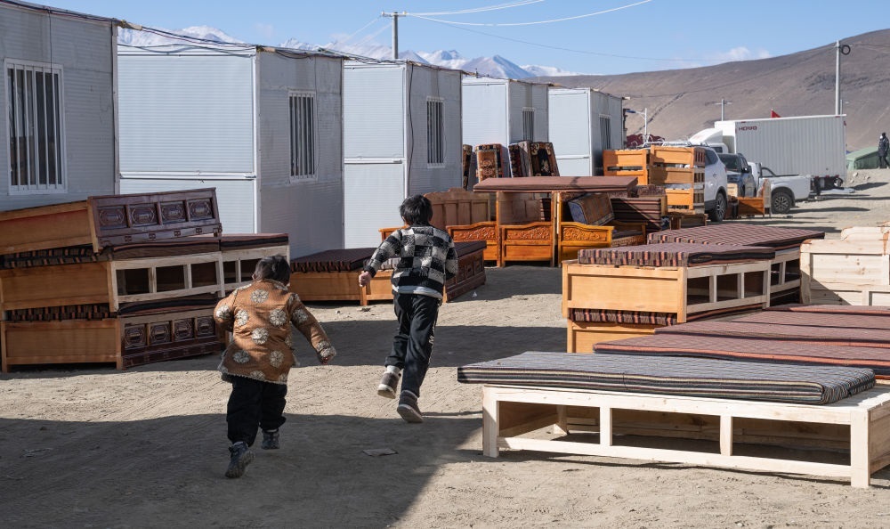 2025年1月13日，在定日縣嘎旦村，兩個孩子在剛運來的兩排藏床間奔跑。新華社記者丁增尼達(dá) 攝