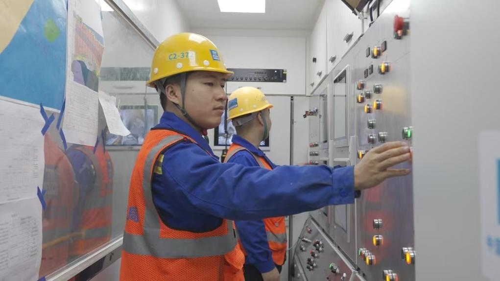 盾構(gòu)司機何曉波在駕駛室內(nèi)調(diào)試盾構(gòu)機參數(shù)。（劉芬攝）