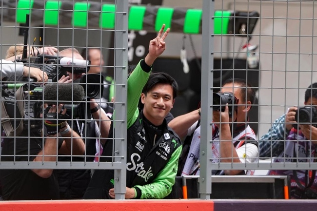 2024年4月19日，索伯車隊中國車手周冠宇（中）在練習(xí)賽前向觀眾致意。當(dāng)日，F(xiàn)1中國大獎賽在上海開賽。中國車手周冠宇主場首秀參賽。新華社記者 夏一方攝