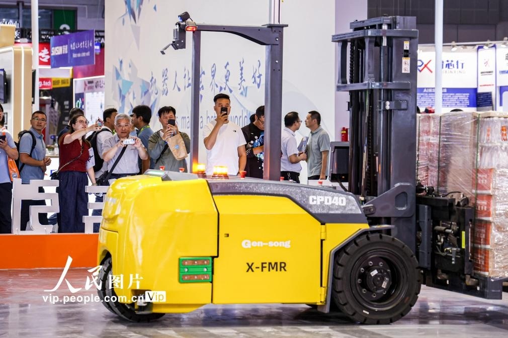 第24屆中國(guó)工博會(huì)現(xiàn)場(chǎng)，觀眾觀看叉取機(jī)器人作業(yè)演示。王初攝（人民圖片網(wǎng)）