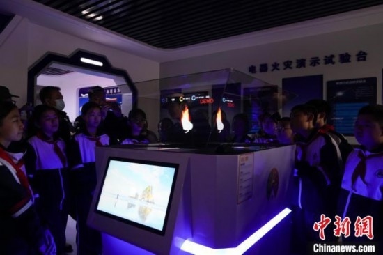 圖為學(xué)生們參觀道里區(qū)消防救援大隊消防科普體驗館內(nèi)幻影成像燃燒三要素實驗臺。中新社記者 趙宇航 攝