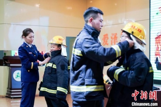 圖為學(xué)生們現(xiàn)場穿戴消防頭盔和戰(zhàn)斗服。中新社記者 趙宇航 攝