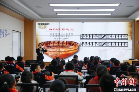 圖為學(xué)生在“國寶音樂會(huì)”社教課中了解舞蹈紋彩陶盆。中新社記者 馬銘言 攝
