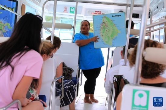 3月15日，一名導(dǎo)游在游艇上為游客介紹塞舌爾拉迪格島。新華社記者 董江輝 攝