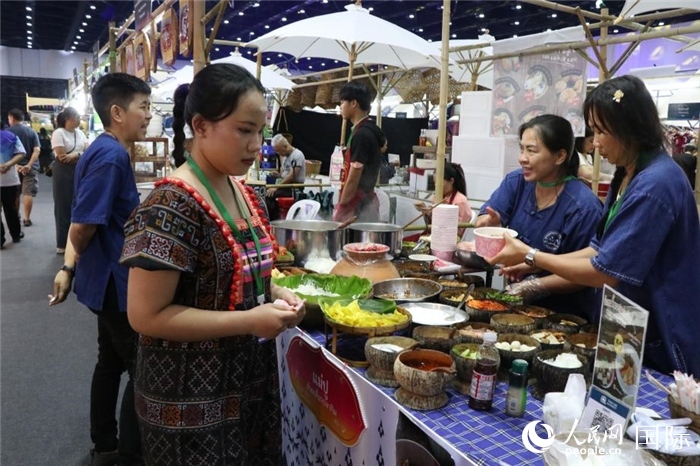 游客在攤位前購買特色美食。朱瀟逸攝