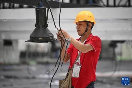 4月4日，工作人員在海南國(guó)際會(huì)展中心內(nèi)布設(shè)燈光。