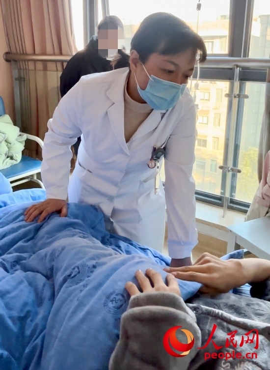 鄧茜查房時(shí)詢(xún)問(wèn)患者情況。人民網(wǎng)記者 金慧慧攝