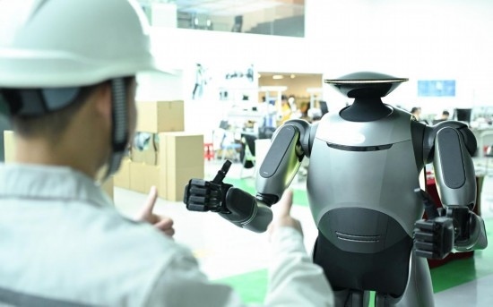 在廣汽研究院，人形機器人團隊的周仁義在演示GoMate機器人互動功能（新華社記者 鄧華 攝）