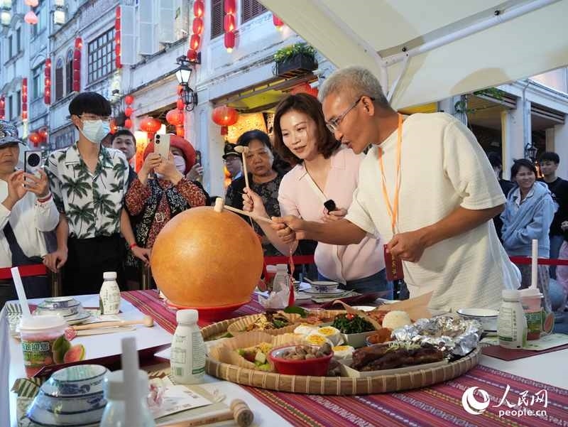 嘉賓品嘗海南傳統(tǒng)美食“煎堆”。人民網(wǎng)記者 張力洋攝