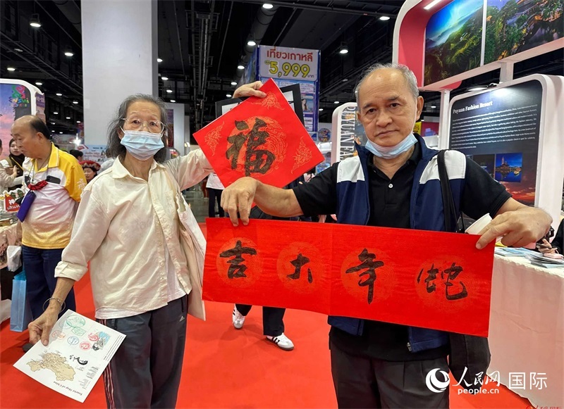 2025蛇年春節(jié)，泰國市民展示他們領(lǐng)到的華人手寫春聯(lián)。人民網(wǎng)記者 簡承淵攝