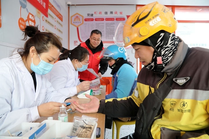 2025年3月5日，志愿者在山東省棗莊市市中區(qū)一工會(huì)驛站為外賣員免費(fèi)測(cè)量血糖。新華社發(fā)（王海楠攝）