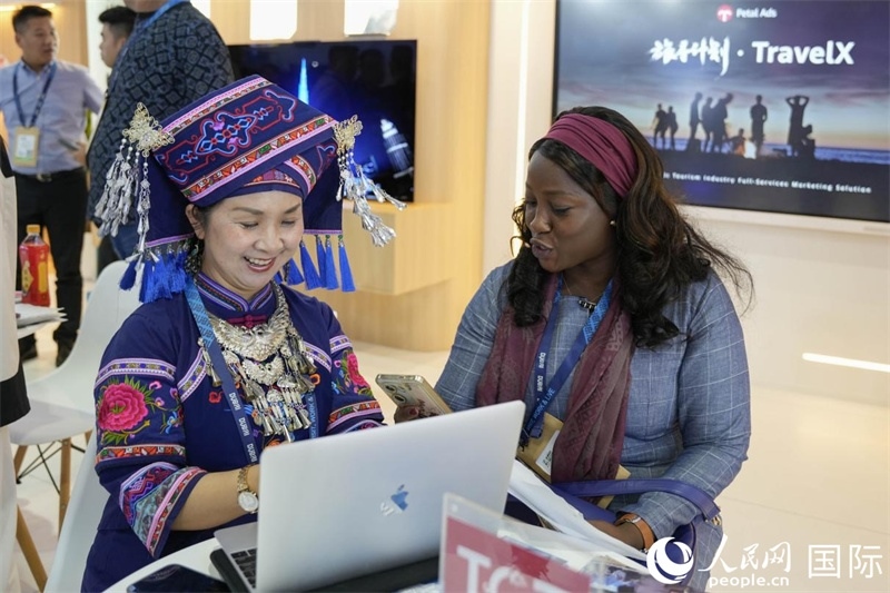 來自廣西的旅游業(yè)者同客戶交流。人民網(wǎng)塔里克·易卜拉欣攝