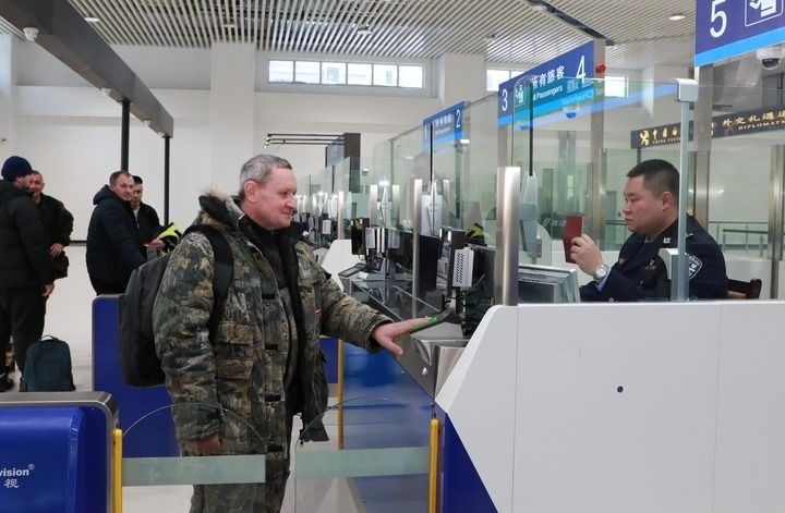 2024年12月10日，在黑河公路口岸旅檢大廳，黑河出入境邊防檢查站民警為首班次客車入境旅客辦理邊檢通關(guān)手續(xù)。當(dāng)日，中國黑河公路口岸—俄羅斯卡尼庫爾干公路口岸旅客運(yùn)輸正式開通。新華社發(fā)（劉松攝）