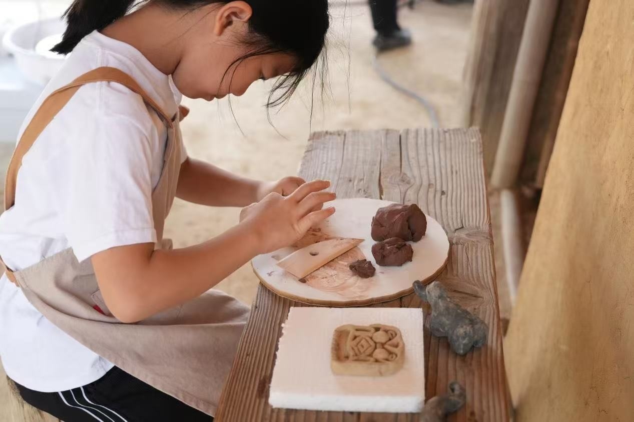 游客制作良渚特色陶藝品。良渚博物院供圖