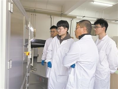 圖為安工大材料科學與工程學院碩士研究生余威（右一）在實驗室開展研究。安工大供圖