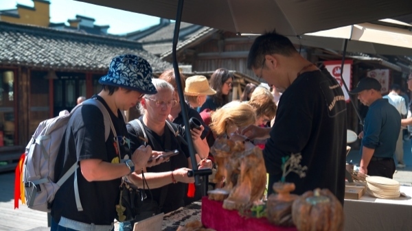 “五一”期間，游客正在烏鎮(zhèn)“水鄉(xiāng)碼頭”挑選購(gòu)買文創(chuàng)產(chǎn)品。受訪者供圖