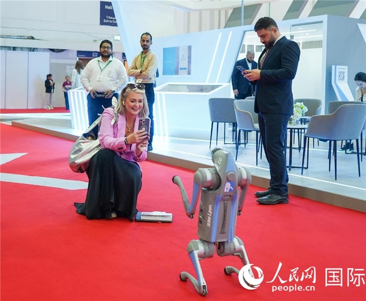 與會(huì)嘉賓被中企機(jī)器人吸引。人民網(wǎng) 塔里克·易卜拉欣攝