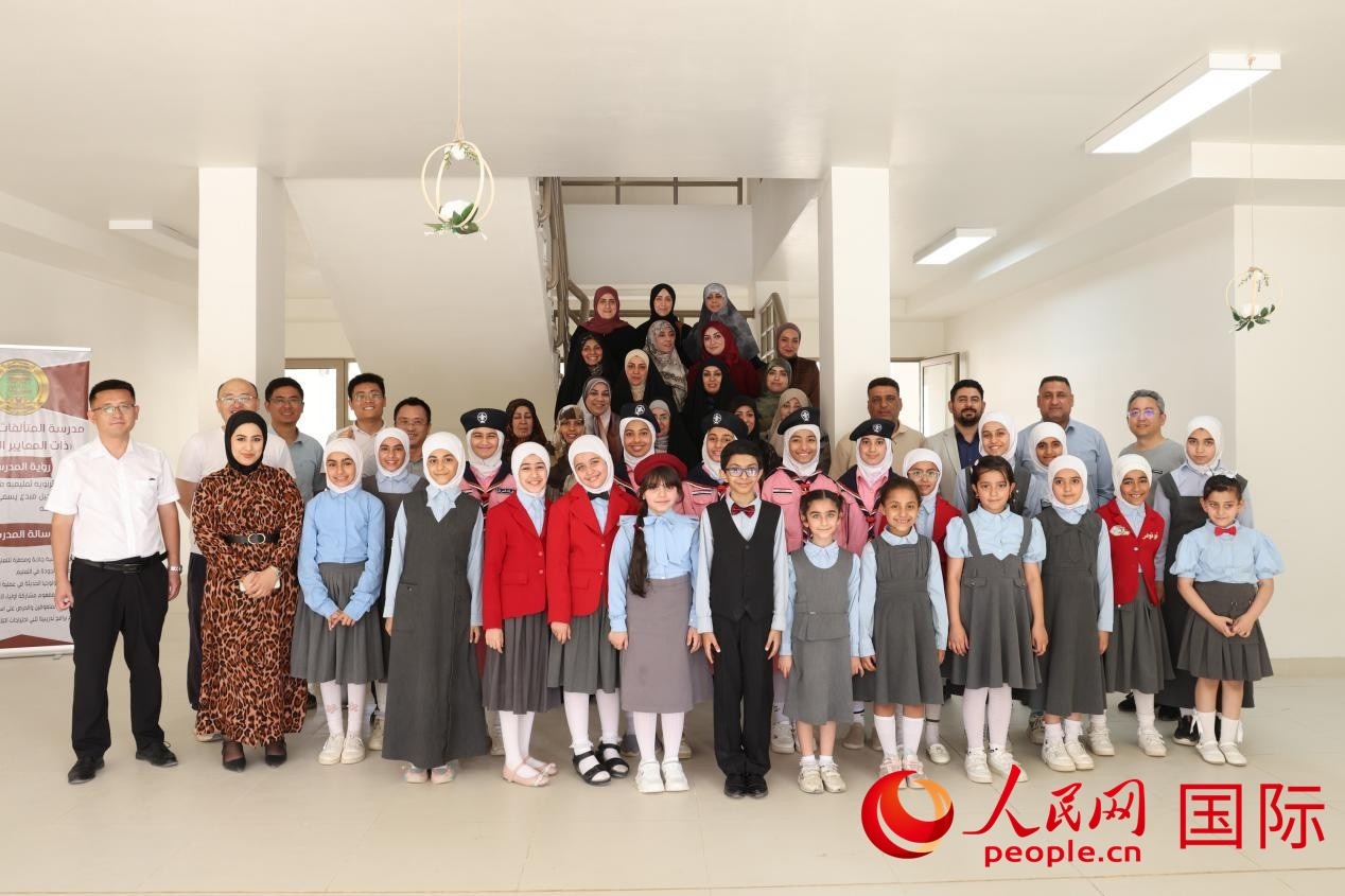 中國電建員工與阿爾穆塔?阿里卡特國際學校的師生及政府官員等合影。人民網(wǎng)記者 薛丹攝