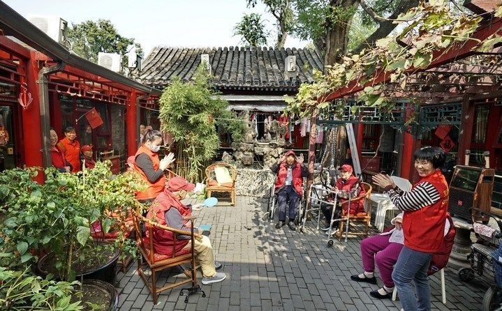 2024年10月12日，鐘樓灣胡同的老年人在社區(qū)內(nèi)的四合院養(yǎng)老驛站休閑。2017年起，北京市先后開展了兩輪背街小巷環(huán)境整治提升行動(dòng)，完整保留了中軸線生活建筑群的歷史信息，并根據(jù)居民的生活和居住方式進(jìn)行適配化的更新和改造，極大地改善了生活環(huán)境。2023年鐘樓灣胡同被評(píng)為“北京最美街巷”。