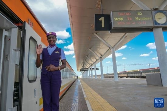5月31日，在蒙內(nèi)鐵路內(nèi)羅畢站，一名乘務(wù)員在即將開(kāi)往蒙巴薩的E2次列車(chē)旁等候乘客。新華社記者 楊光 攝