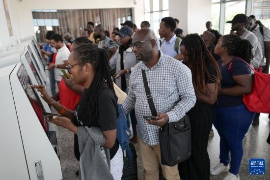 5月31日，在蒙內(nèi)鐵路內(nèi)羅畢站，乘客在自助取票機(jī)前排隊(duì)取票。新華社記者 楊光 攝