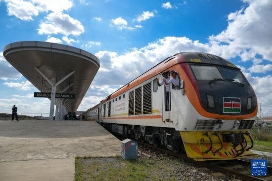 5月31日，在蒙內(nèi)鐵路內(nèi)羅畢站，機(jī)車(chē)駕駛員蔣立平（右）和博爾在即將開(kāi)往蒙巴薩的E2次列車(chē)上揮手致意。新華社記者 楊光 攝