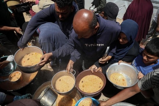 5月28日，人們?cè)诩由吵俏鞑康纳程犭y民營(yíng)領(lǐng)取救助食物。新華社發(fā)（里澤克·阿卜杜勒賈瓦德攝）